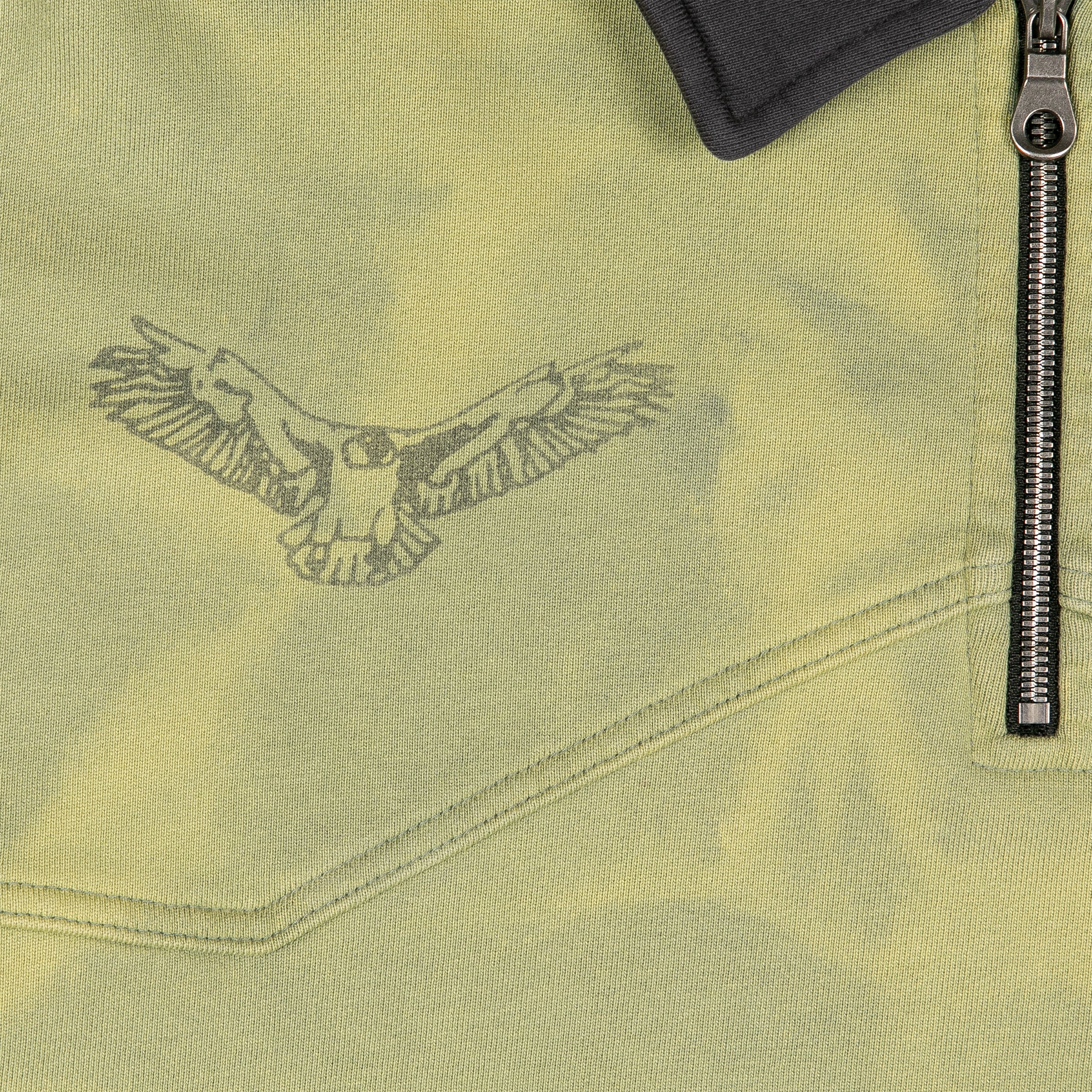 Black line art of a soaring eagle with wings spread, printed on the left chest above the seam. Silver zipper and chest panel stitching details. 