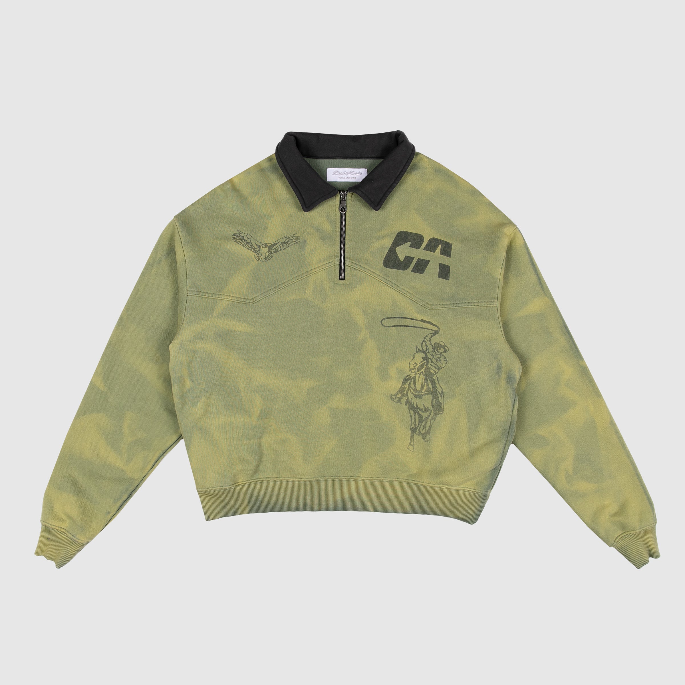 Green enzyme washed quarter-zip sweatshirt with black collar, featuring black graphic prints of a cowboy on horseback, a flying eagle, and "DA" monogram on the chest.